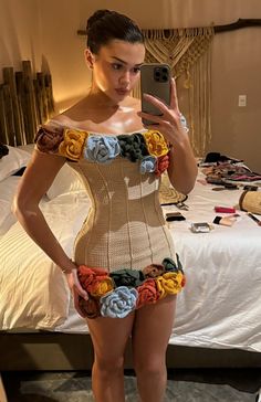 a woman taking a selfie while wearing a corset made out of crochet