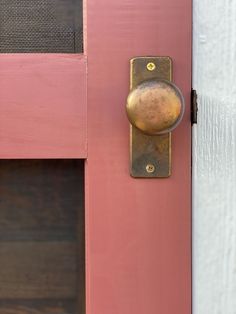 a pink door with a brass handle on it