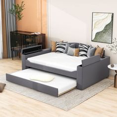 a modern day bed with pull out trundle in the middle of a living room