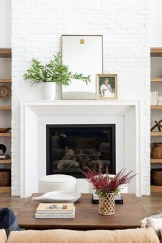 the living room is clean and ready for us to use it's white brick fireplace