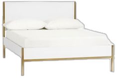 a white bed with gold frame and pillows