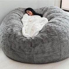 a woman laying in a large bean bag chair