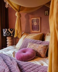 a bed with purple comforter and pillows on it