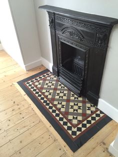 a fireplace in the corner of a room next to a wooden floor and white walls