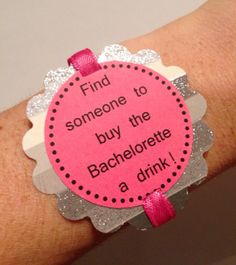 a person's arm with a pink and silver bracelet that says, find someone to buy the bachelorette a drink