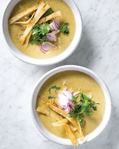 two bowls filled with soup on top of a table