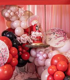 an assortment of balloons, umbrellas and cake on display