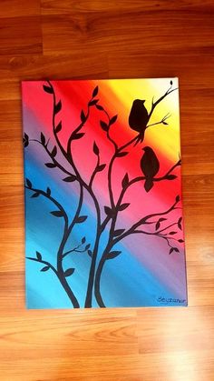 a painting of two birds sitting on a tree branch in front of a rainbow colored sky