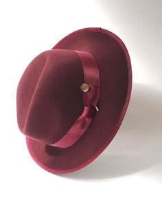 A timeless chic Trilby featuring a tonal satin hat band and inner petersham ribbon. Handcrafted in wool felt with a wired brim for fashioning to suit. Maximum size 57cm. Inside adjuster for one size fits all. Elegant Panama Hat With Flat Crown For Fall, Elegant Flat Brim Felt Hat For Fall, Elegant Felt Hat With Flat Brim For Fall, Elegant Solid Color Fall Hats, Elegant Fedora With Curved Brim For Fall, Elegant Flat Brim Panama Hat For Fall, Elegant Curved Brim Fedora For Fall, Elegant Fall Fedora With Curved Brim, Elegant Felt Hat With Flat Crown For Fall