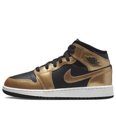 The Air Jordan 1 Mid SE 'Metallic Gold Black' is a classic silhouette with a modern twist. The black upper is complemented by metallic gold accents on the Swoosh, Jumpman branding and leather overlays. The sneaker is finished with a black tongue and midsole, and a rubber sole. This sneaker is perfect for everyday wear, and its metallic gold accents make it a stylish addition to any outfit. The inspiration behind the design is the iconic Air Jordan 1 series, which has been a staple of the sneaker world since its release in 1985. (AJ1/SNKR/Retro/Light/Mid Top/Non-Slip/Basketball/Wear-resistant) Gold Sneakers With Metallic Logo For Streetwear, Classic Gold Sneakers For Streetwear, Gold Casual Sneakers With Metallic Logo, Casual Gold Sneakers With Metallic Logo, Gold Sneakers With Foil Embossed Logo And Round Toe, Air Jordan 1 Mid Gs, Black Tongue, Retro Light, Air Jordan 1 Mid Se