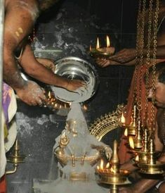 people are lighting candles in a temple