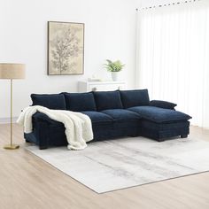 a living room with a blue sectional couch and white rug in front of the window