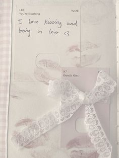 a card with a white ribbon attached to it's side and some writing on the back