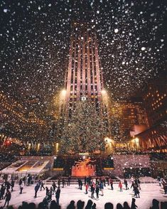 the rockefeller christmas tree in new york city is lit up with lights and people skating on an ice rink