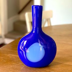 a blue vase sitting on top of a wooden table