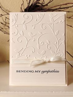 a white greeting card with a ribbon on the front and writing sending my sympathys