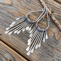 Silver Teardrop Boho Fan Earrings: These silver fan paddle earrings are the perfect mix of geometric & boho and will compliment any outfit! Graduated hammered paddles hang from a beautifully crafted teardrop focal point. These earrings are handcrafted from silver plated jewelers grade brass. They are approximately 2.75 inches in length and .62 inches at the widest portion. To view more of my original jewelry designs, visit: https://www.etsy.com/shop/TheBeadCounter Pierced Metal Drop Earrings, Pierced Drop Metal Earrings, Nickel-free Drop Metal Earrings, Nickel Free Long Drop Teardrop Earrings, Nickel-free Long Drop Teardrop Earrings, Unique Silver Dangle Teardrop Earrings, Unique Silver Teardrop Dangle Earrings, Long Drop Metal Chandelier Earrings With Ear Wire, Handmade Drop Linear Earrings