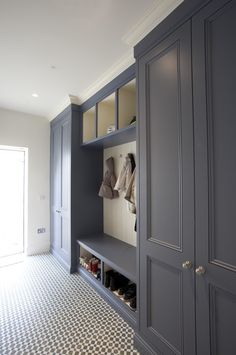 a room with gray cabinets and shoes on the shelves in it's closets