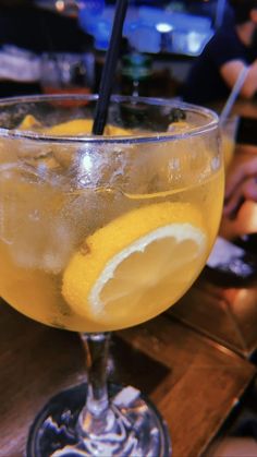 a glass filled with lemonade sitting on top of a wooden table