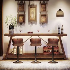 two brown chairs sitting at a table with bottles and wine glasses on top of it