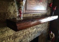 a fire place with vases on top of it next to a painting and candles