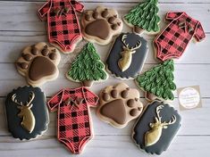 decorated cookies are arranged in the shape of dogs paws and sweaters with trees on them