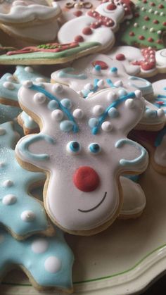 decorated christmas cookies on a plate with frosting