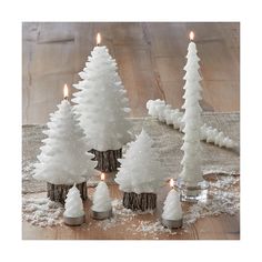 small white christmas trees with lit candles in them