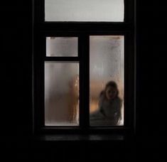 a person standing in front of a window with frosting on the windowsills