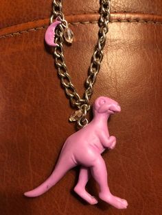 This 2 inch vintage 90s purple, dinosaur pendant is hung on a repurposed 16 inch silver chain with a lobster claw clasp. It also features a purple moon charm and pink, crystal beads. Purple Dinosaur, Phoenix Jewelry, Dinosaur Pendant, Triangle Jewelry, Dinosaur Necklace, Purple Moon, Phoenix Pendant, Silver Dragon Necklace, Hummingbird Pendant