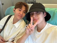 two young men sitting next to each other on a hospital bed posing for the camera