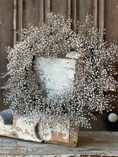 a vase filled with white flowers on top of a wooden table