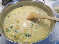 a wooden spoon in a pot filled with food on top of a stove next to other dishes