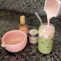 a counter top with jars and containers on it, one containing liquid and the other containing an empty container