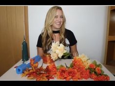 a woman sitting at a table with flowers in front of her