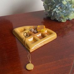 a table with a yellow plate and necklace on it next to a blue hydrant