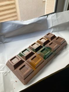 a chocolate bar sitting on top of a piece of white paper next to a window