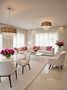 a living room filled with white furniture and pink flowers