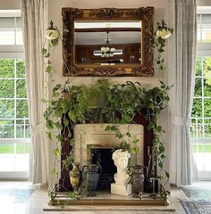 a living room filled with furniture and a fire place covered in greenery next to a mirror