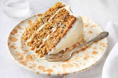 a piece of carrot cake on a plate with a fork and napkin next to it