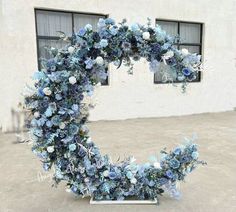 a heart shaped wreath made out of blue flowers