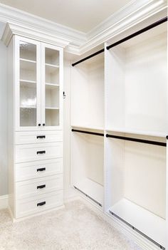 an empty walk in closet with white drawers and black handles on the door, next to a toilet