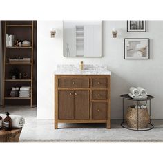 a bathroom vanity with marble top and wooden cabinetry, along with other items on the floor