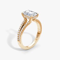 a gold engagement ring with an oval cut diamond in the center and side stones on the band