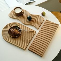 a white table topped with plates and bowls filled with food on top of wooden place mats