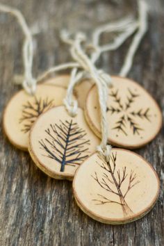 four wooden ornaments with small trees on them