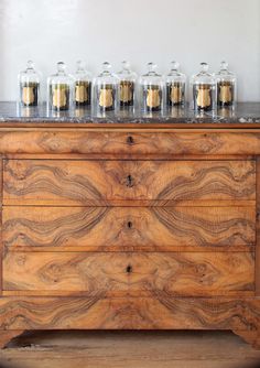 a wooden dresser with jars on top of it