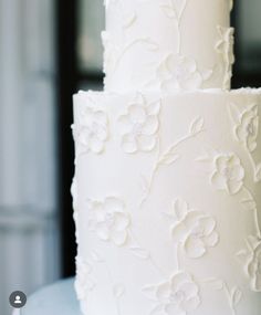 a three tiered white wedding cake with flowers on it