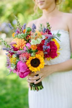 a woman holding a bouquet of flowers in her hands