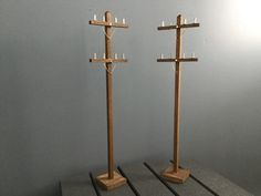 two wooden candlesticks are on display in a room with gray walls and flooring